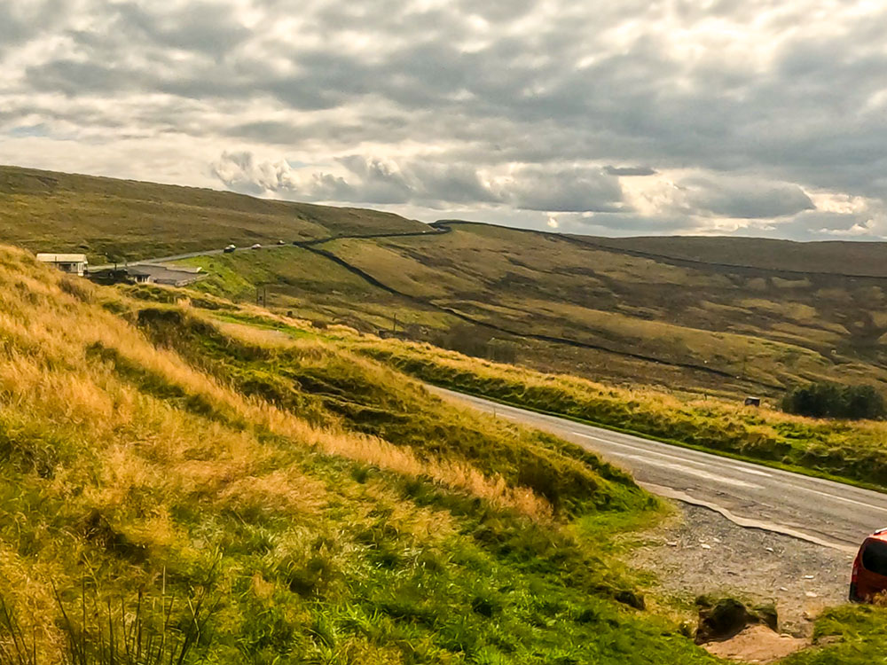 The path turns left upon reaching Clitheroe Road, heading towards Pendle Ski Slope and the Wellsprings